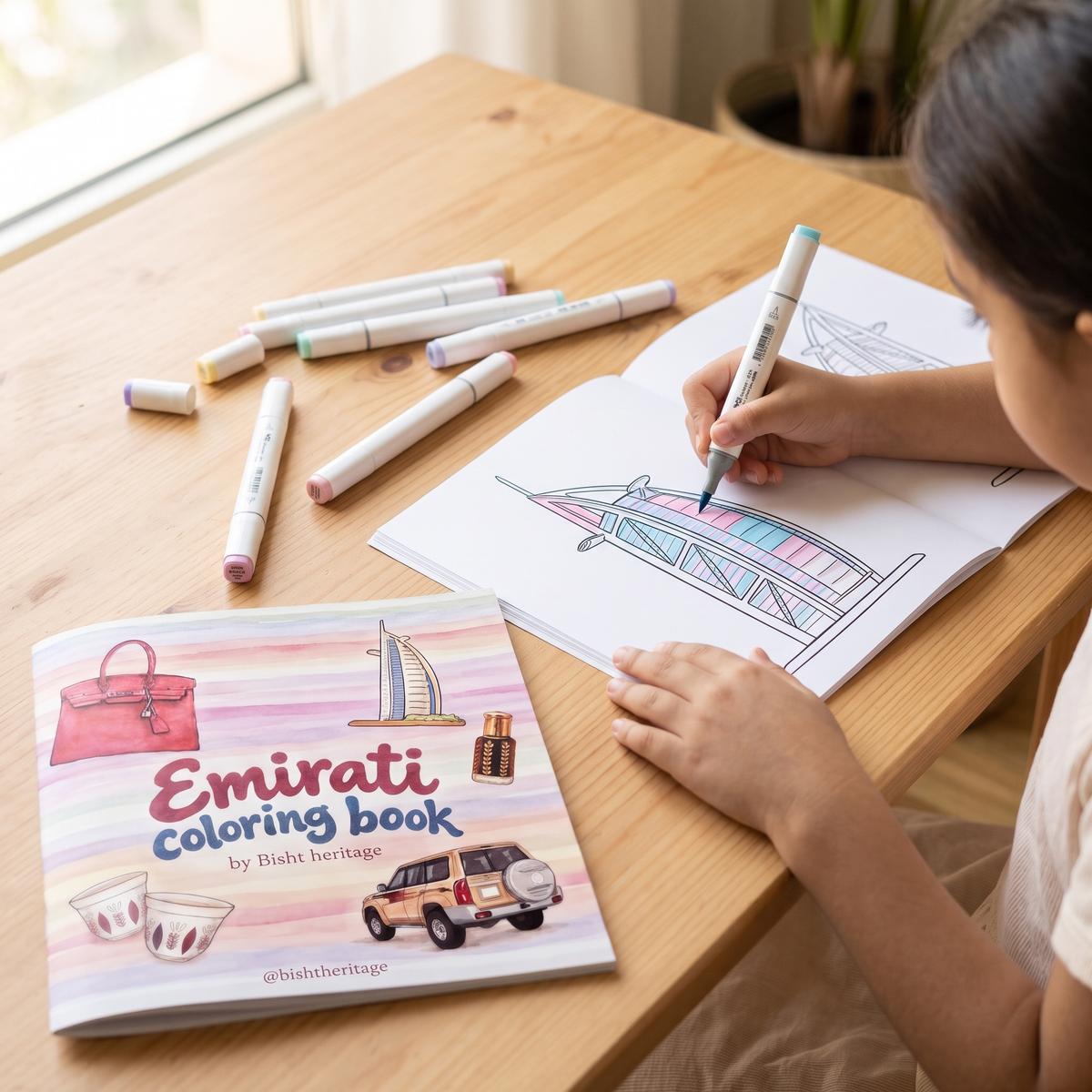 Girl coloring the Burj Al Arab page with marker pens